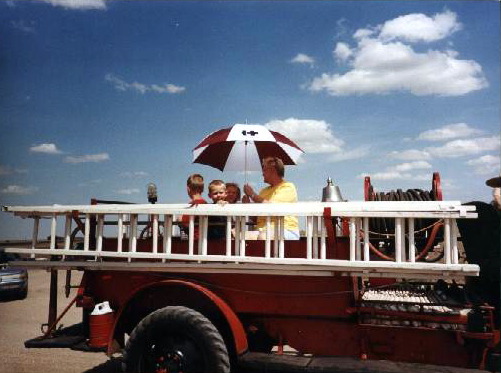 Jan Eisenhour North with grandchildren Brandon North, Aidan and Sarah Martin on McCracken's "Old" Fire truck on the trail ride